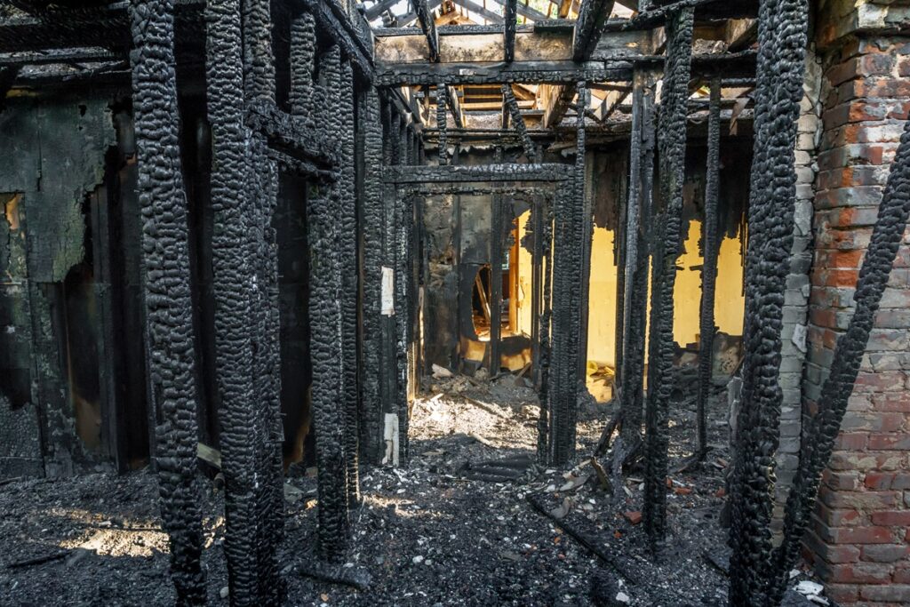 Completely burned interior structural beams after total fire loss in NYC property