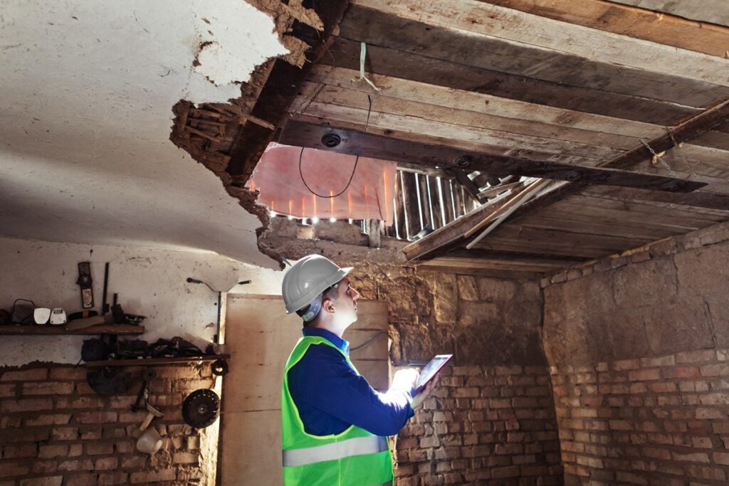Insurance adjuster inspecting ceiling damage during property damage claim inspection